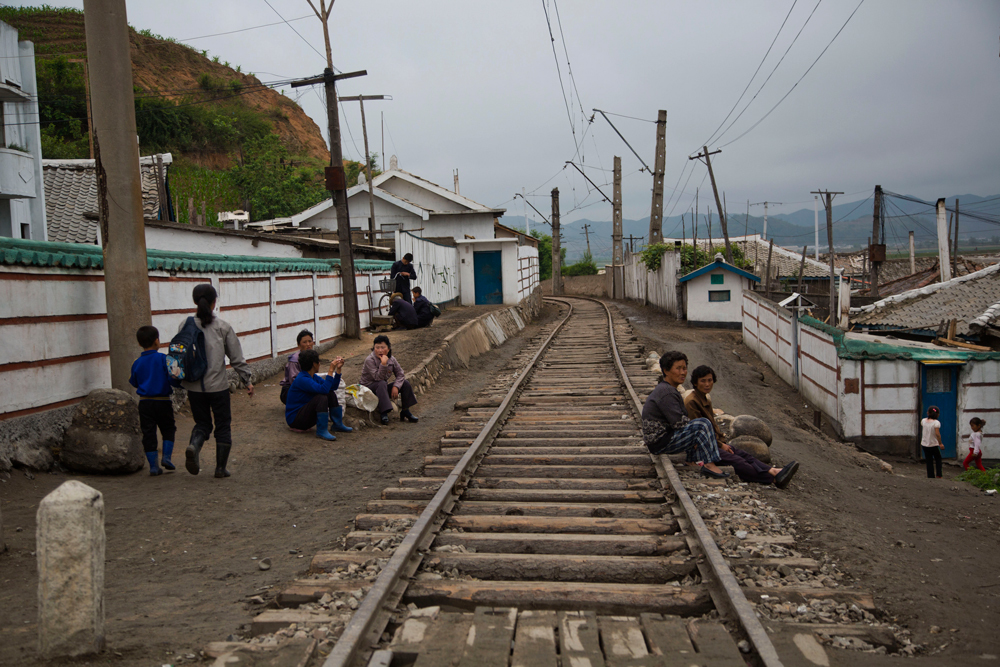 Alcuni abitanti di un villaggio nella provincia di Hamgyong si riposano lungo i binari del treno. - (David Guttenfelder, Ap/Ansa)