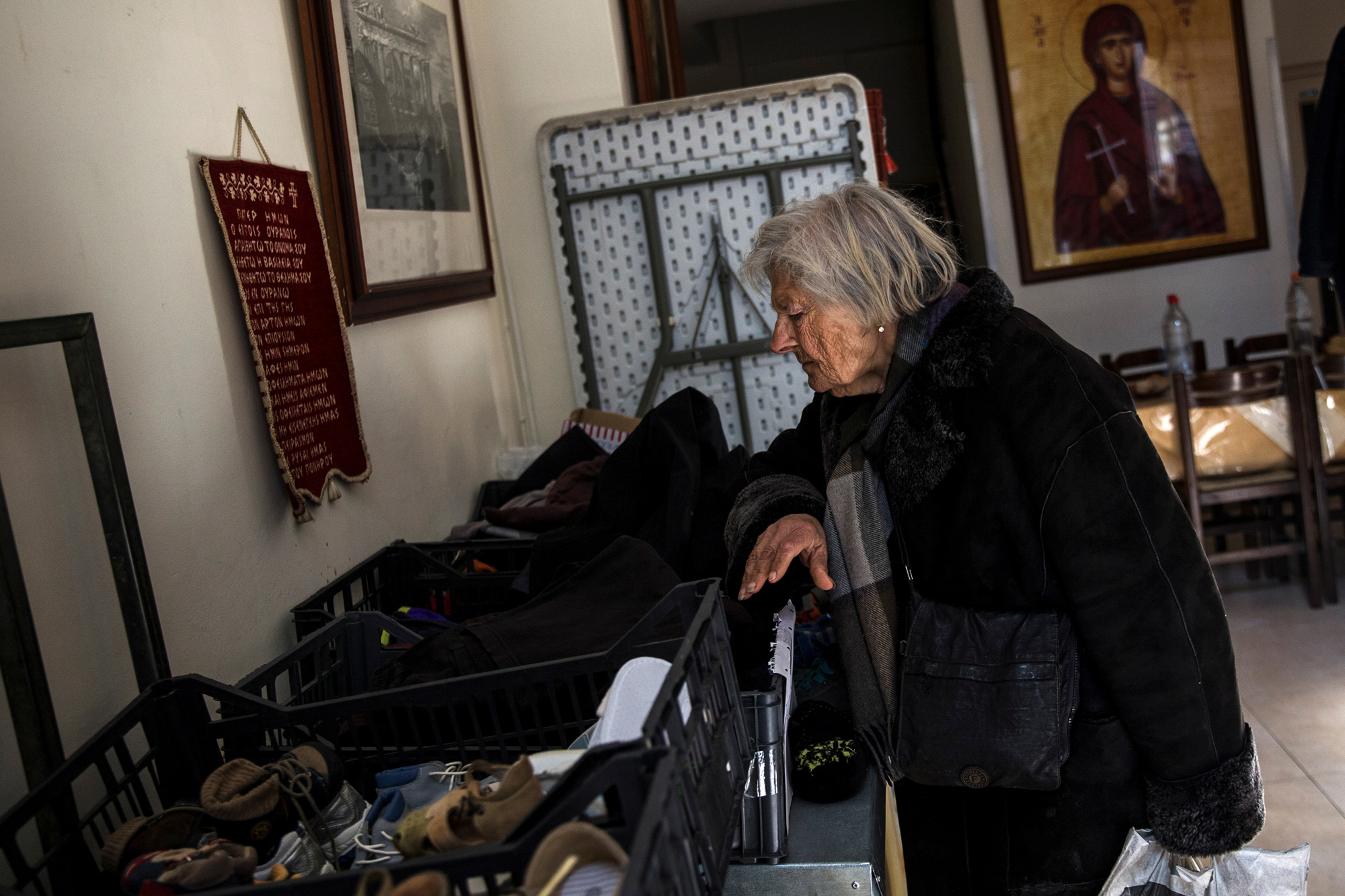 Una donna cerca dei vestiti tra le donazioni arrivate alla chiesa ortodossa di Atene. - (Alkis Konstantinidis, Reuters/Contrasto)